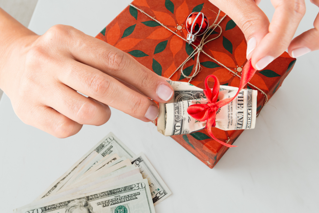 wrapping up 2024 financials illustrated here by person wrapping money with a red bow